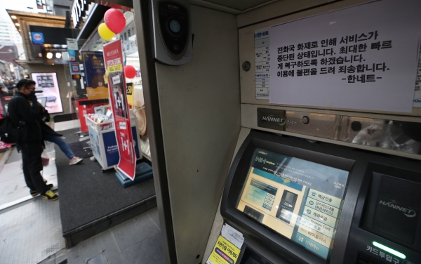 KT 아현국사 화재로 통신장애가 이틀째 계속되고 있는 25일 오후 서울의 한 상점가 ATM 기기에 장애 관련 안내 문구가 붙어있다.(사진-연합뉴스)