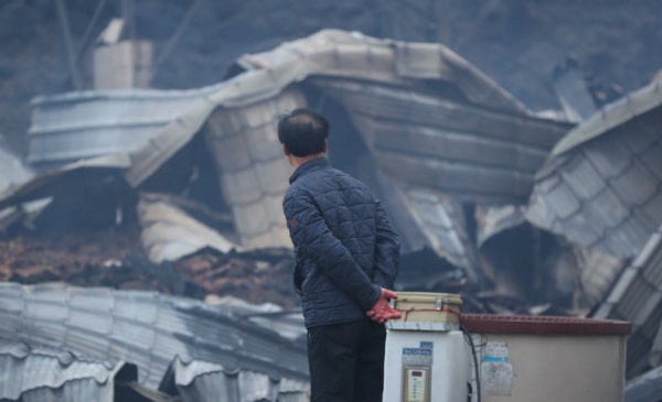 5일 오전 전날 강원도 고성군 토성면에서 시작된 산불이 번진 속초시 장천마을에서 한 주민이 불에타 무너진 집을 바라보고 있다.