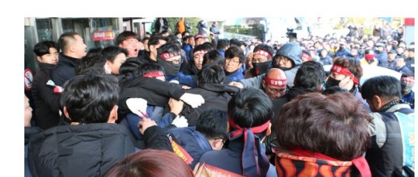 한국GM 창원공장 비정규직 노동자들이 지난 23일 대량해고 철회를 요구하며 회사에 진입해 사 측에서 고용한 용역과 몸싸움을 하고 있다. (사진-연합뉴스)