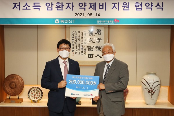 엄대식 동아에스티 회장(왼쪽)과 유승흠 한국의료지원재단 이사장이 저소득 암환자 약제비 지원 업무 협약식에서 기념촬영을 하고 있다.(사진-동아에스티)