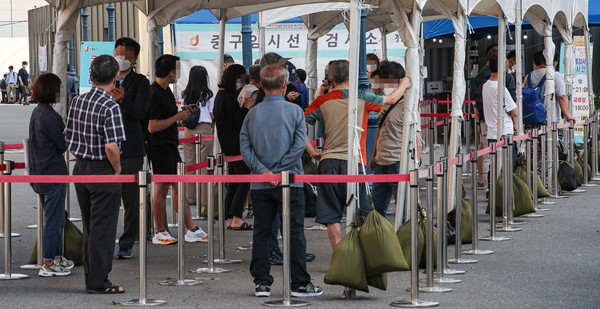 3일 오전 서울 중구 서울역 광장에 설치된 신종 코로나바이러스 감염증(코로나19) 선별검사소에 검사를 받으려는 시민들이 줄지어 서 있다.(사진-연합뉴스)