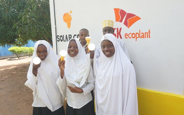 SK에코플랜트는 아프리카 어린이들을 위해 태양광 기반 전력 보급시설인 ‘솔라카우(Solar-Cow)’를 설치했다고 이날 밝혔다. 사진은 학생들이 충전된 솔라밀크를 들고 웃고 있는 모습.(사진-SK에코플랜트) 
