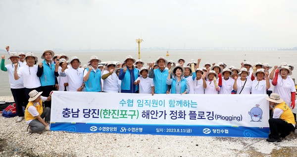 ‘해안가 환경정화 플로깅’ 캠페인 활동에 앞서 모든 참가자들이 함께 기념촬영을 하는 모습. (사진=Sh수협은행)